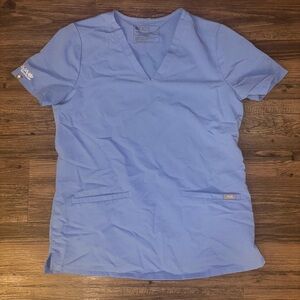 Figs women’s ceil blue scrub top with Aya Healthcare logo